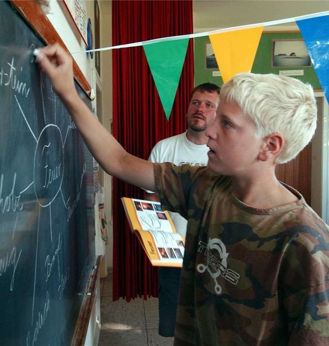 Individuelle Betreuung bekommt Schüler Sven Glienke (r.) von Lehrer Henning Schlüter auf der Hallig Nordstrandischmoor in der wohl kleinsten Schule Deutschlands. Archivfoto: dpa